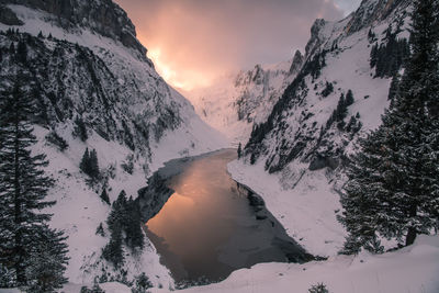 Scenic view of snow covered mountains against sky during sunset