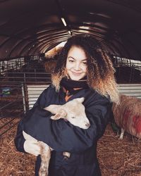 Portrait of young woman holding lamb