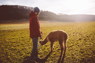 Man with animal standing on field