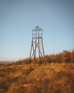 Windmill on field against clear sky