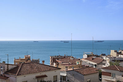 High angle view of buildings by sea against clear sky