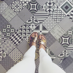 Low section of woman standing on tiled floor