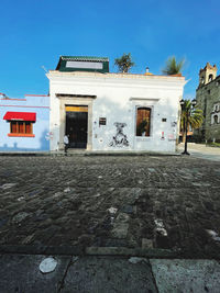 Exterior of building by street against blue sky