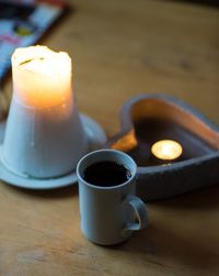 Espresso cup with lit candles on table