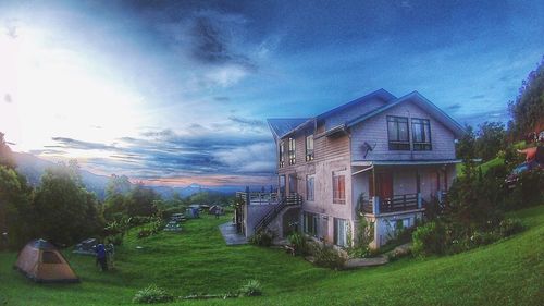 Houses by trees against sky