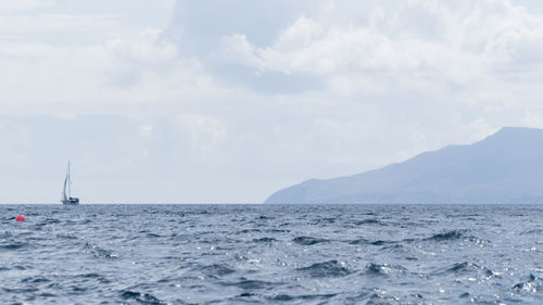 Sailboat sailing on sea against sky