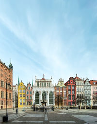 Buildings in city against cloudy sky