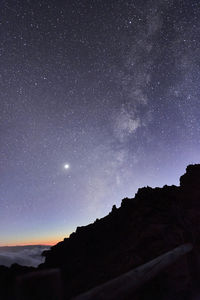 Low angle view of silhouette mountain against sky at night