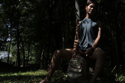 Thoughtful young woman sitting in forest