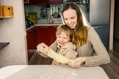 Mother and son preparing food on table