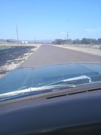 Close-up of road against clear blue sky