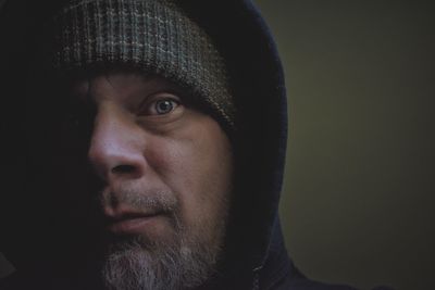 Close-up portrait of mid adult man against black background