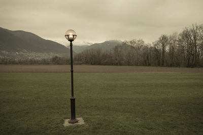 Street light on field against sky
