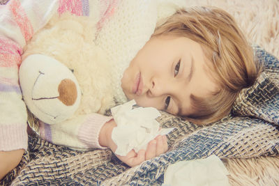 Portrait of cute baby girl lying on bed at home