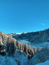 Scenic view of snowcapped mountains against clear blue sky