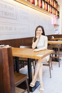 Portrait of smiling woman sitting in cafe