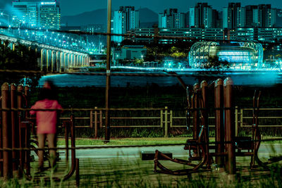 Man and woman in illuminated city against sky at night