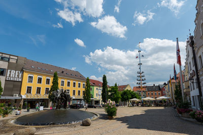 Buildings in city against cloudy sky