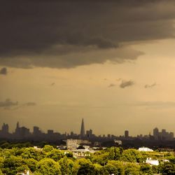 View of cityscape against cloudy sky