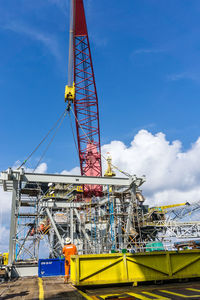 Low angle view of crane against blue sky