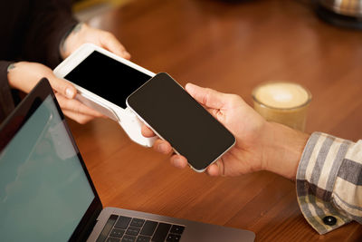 Midsection of woman using digital tablet on table