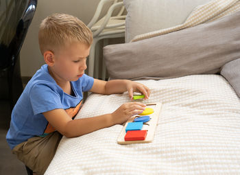 Boy playing with toy blocks at home