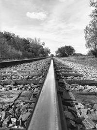 Surface level of railroad tracks against sky