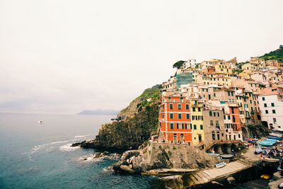 Buildings by sea against sky