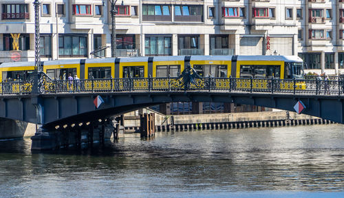 Bridge over river against buildings in city