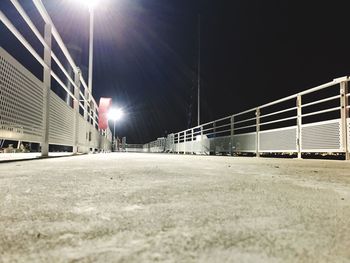 Illuminated walkway against clear sky at night