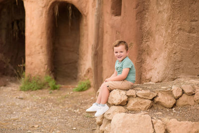 Side view of young woman sitting in tunnel