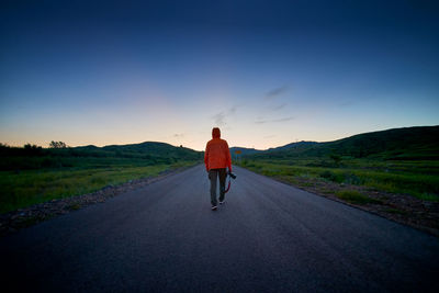 Rear view of man on road against sky