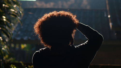 Rear view portrait of silhouette woman standing outdoors