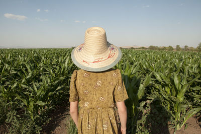 Rear view of woman standing in farm