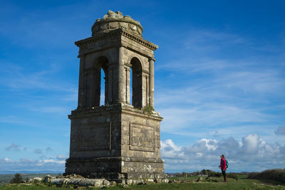 Woman standing by historical built structure