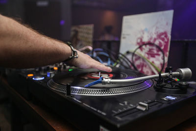Cropped image of dj using sound mixer machine in nightclub