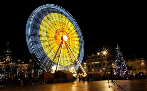 Low angle view of illuminated ferris wheel at night