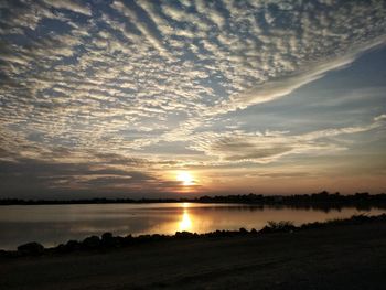 Scenic view of silhouette beach against sky during sunset