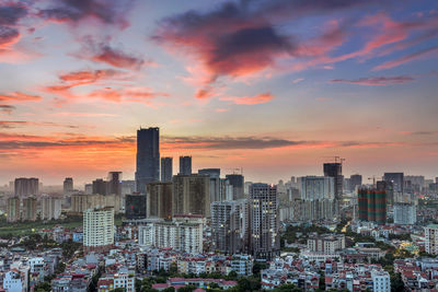 Modern buildings against sky during sunset