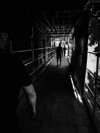 Rear view of silhouette people walking in tunnel