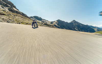 Downhill skateboarder on alpine road