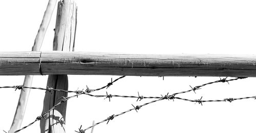 Low angle view of barbed wire against clear sky