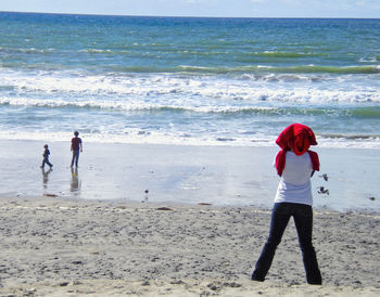 Rear view of women standing on beach