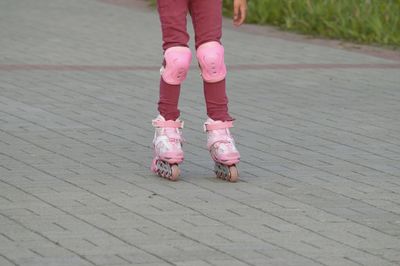 Low section of girl roller skating on street