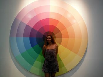 Full length portrait of woman standing against multi colored wall