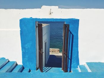 Empty chairs against blue wall of building