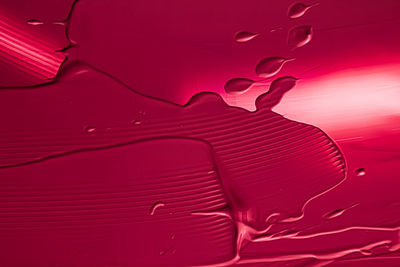 Full frame shot of water drops on red background