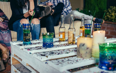 Drinks on table by friends sitting on sofa during party