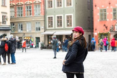 Woman standing on street in city during winter