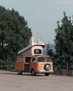 Vintage car against trees in city against sky